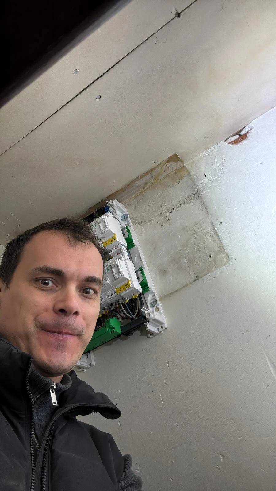 Alexandru Farcaș, électricien et fondateur de Farcas Tech, devant un tableau électrique qu'il vient d'installer