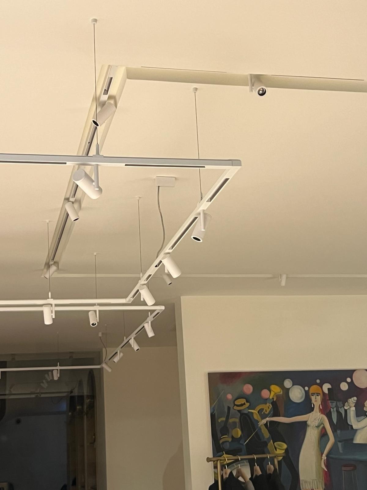 Éclairage sur rails suspendus avec projecteurs orientables dans une boutique